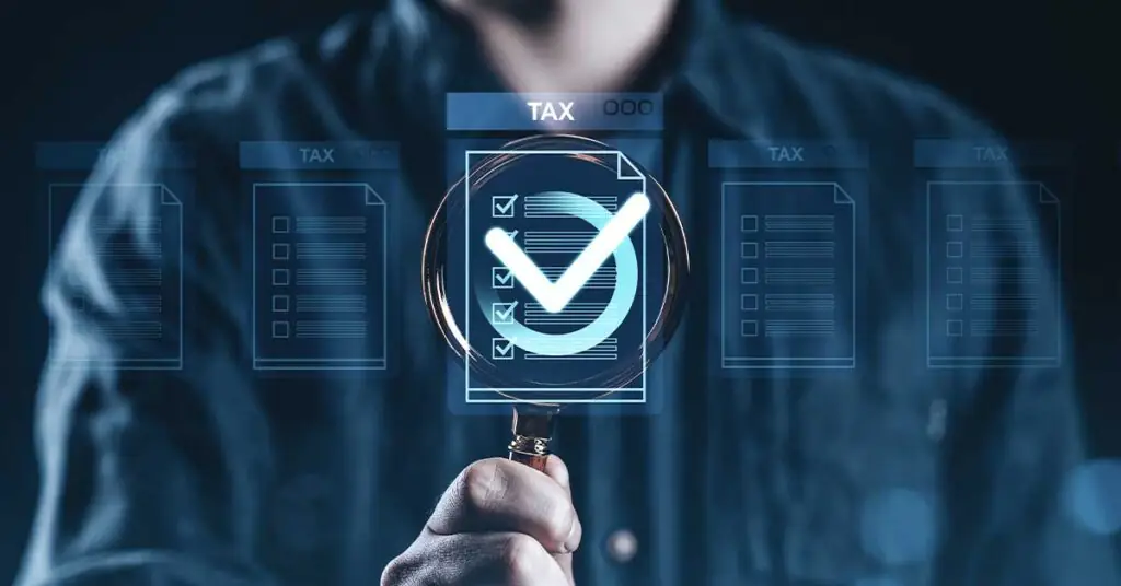 Illustration of a magnifying glass looking at tax compliance documents